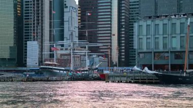 New York, ABD, 5 Ağustos 2025: Tarihi yelkenli gemileri South Street Limanı rıhtımına yanaştı. Aşağı Manhattan rıhtımındaki modern gökdelenlerin önünde direkleri olan vintage uzun gemiler..