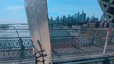 New York, ABD, 5 Ağustos 2025: Mavi çelik köprü yapısı boyunca Manhattan siluetinin görüntüsü. Doğu nehri boyunca şehrin gökdelenlerine bakıyorum. Perçinlerin ve köprünün metal kirişlerinin arasından..