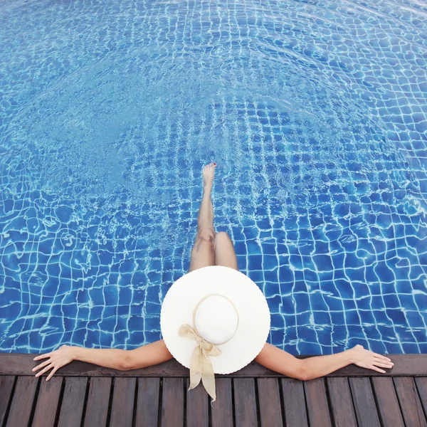Mulher de chapéu relaxante na piscina — Fotografia de Stock