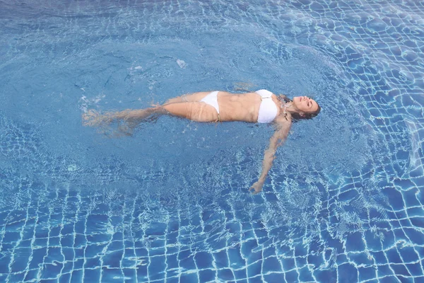 Mulher flutuando na piscina — Fotografia de Stock