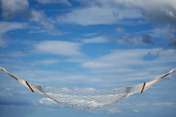 Empty hammock over blue cloudy sky background — Stock Photo, Image