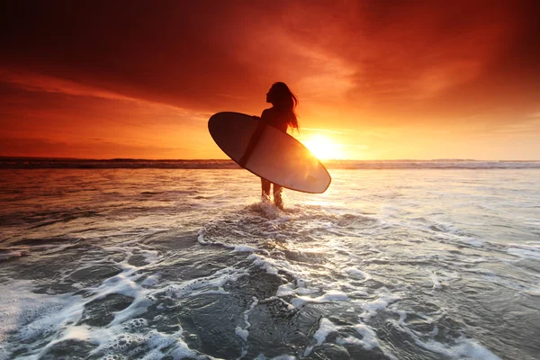 Surfař žena na pláži při západu slunce — Stock fotografie