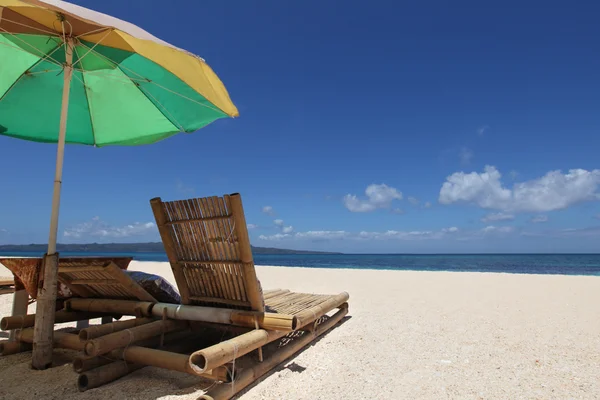 Liegestühle mit Sonnenschirm am Strand — Stockfoto