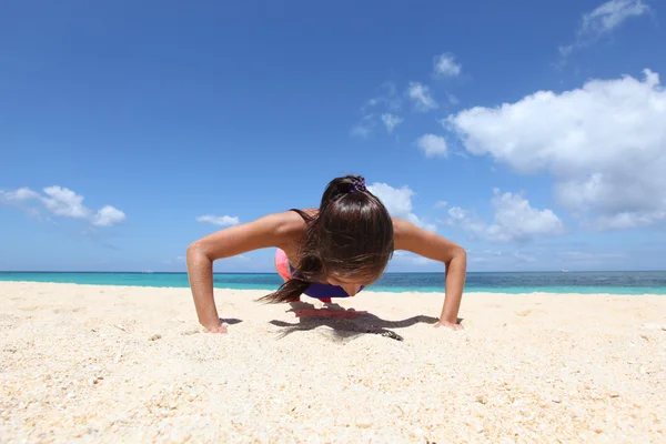 Vrouw doet workout op het strand — Stockfoto
