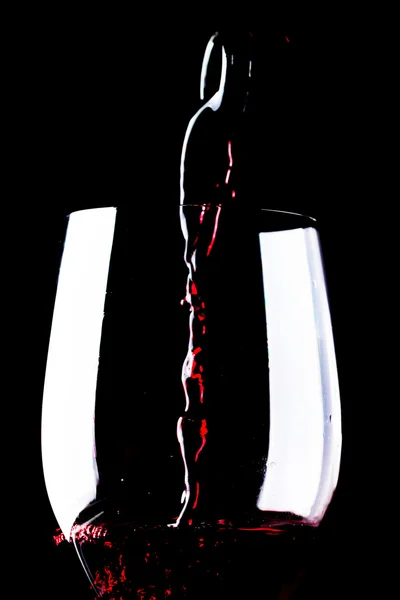 Rotwein im Weinglas auf schwarzem Hintergrund — Stockfoto