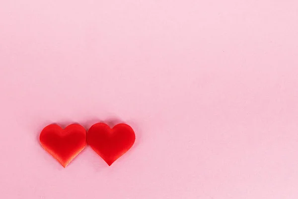 バレンタインデーピンクの紙の背景に2つの赤い絹の心 愛の概念 — ストック写真
