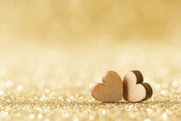 Dvě Malé Ručně Vyrobené Dřevěné Srdce Jasných Zlatých Světlech Bokeh — Stock fotografie