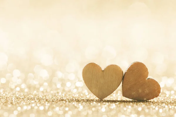 Dvě Malé Ručně Vyrobené Dřevěné Srdce Jasných Zlatých Světlech Bokeh — Stock fotografie