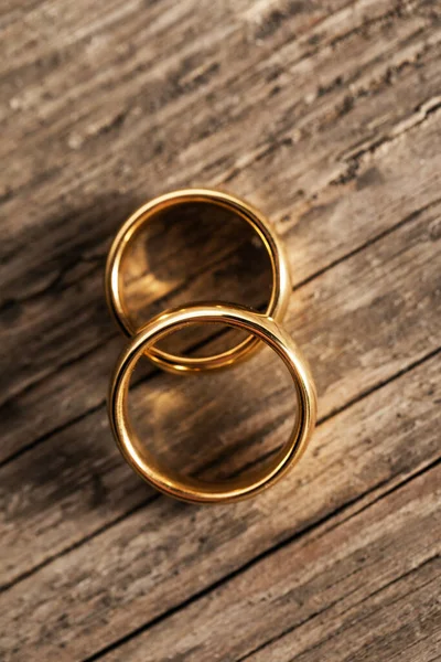 Dva Zlaté Snubní Prsteny Dřevěném Pozadí — Stock fotografie