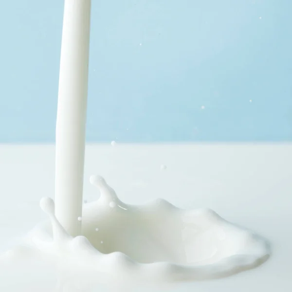 Pouring Milk Splash Blue Background Close — Stock Photo, Image