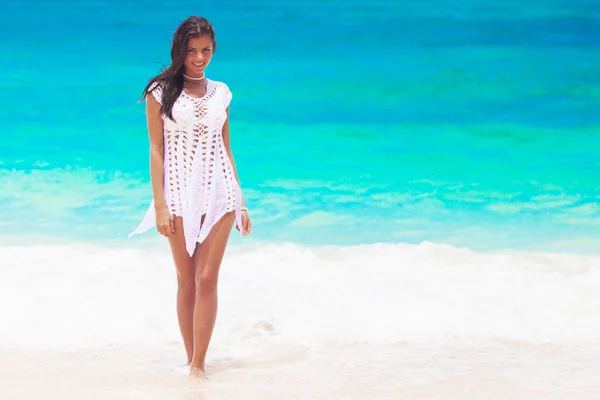 Szczęśliwa Młoda Kobieta Białej Sukience Spaceruje Plaży Tropikalnego Morza Uśmiecha — Zdjęcie stockowe