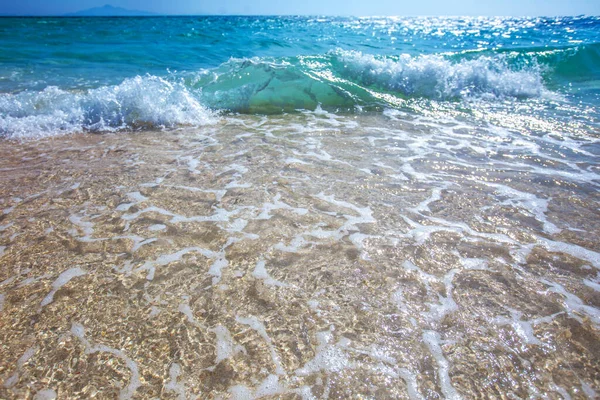 太陽の光で砂浜の海の透明波を背景に — ストック写真