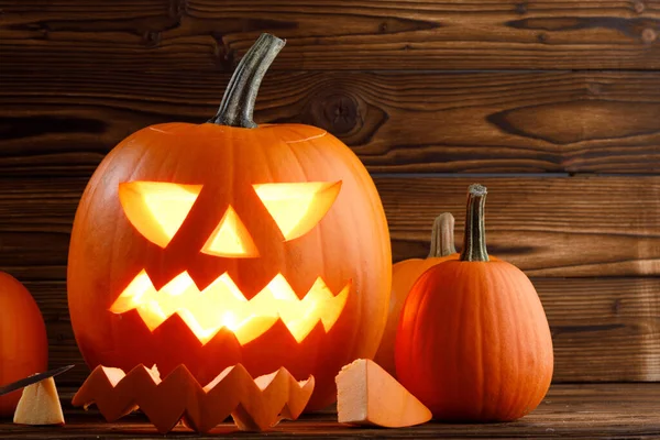Snidade Halloween Pumpa Med Brinnande Ljus Inuti Trä Bakgrund — Stockfoto