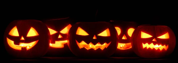Många Halloween Pumpa Glödande Ansikten Rad Isolerade Svart Bakgrund — Stockfoto