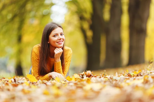 Девушка лежит на осенних листьях — стоковое фото