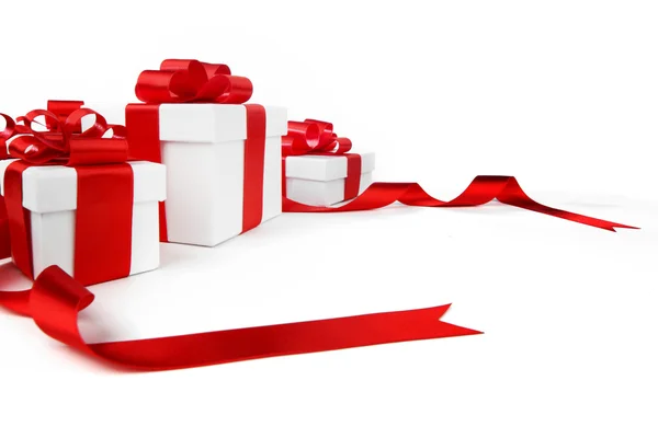 Белые подарочные коробки с красными бантами — стоковое фото