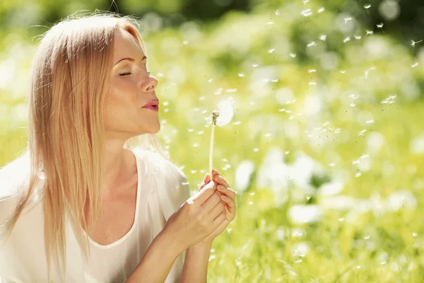 Girl blow on dandelion — Stock Photo, Image