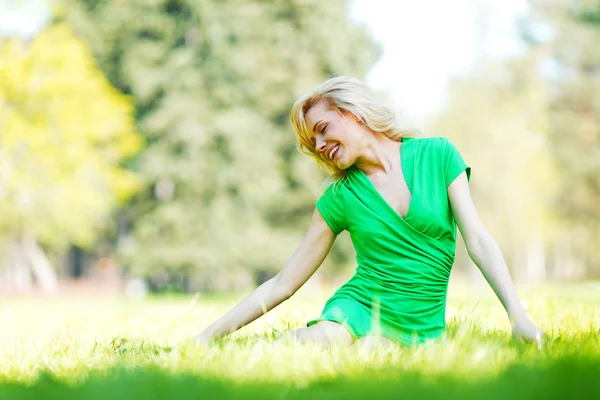 Žena sedící na trávě — Stock fotografie