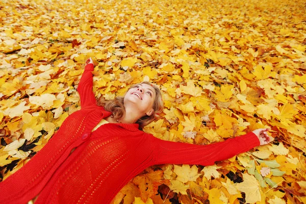 Woman laying on autumn leaves — Stock Photo, Image