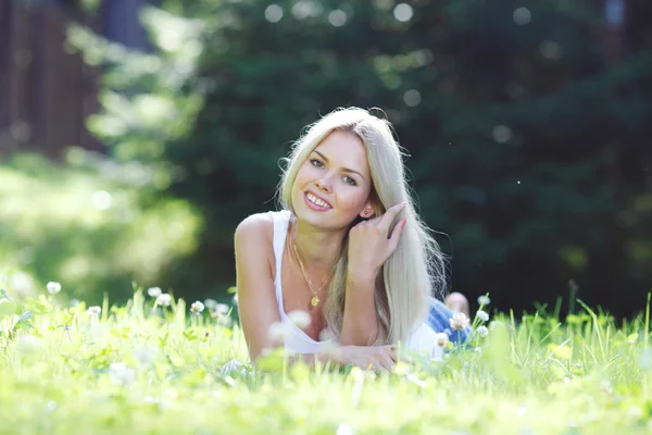 Jonge vrouw liggend op gras — Stockfoto