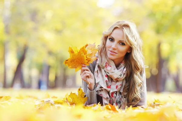 Donna sdraiata in foglie d'autunno — Foto Stock