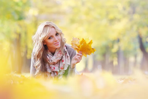 Frau liegt im Herbstlaub — Stockfoto