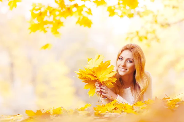 Vrouw met bos van esdoorn bladeren — Stockfoto