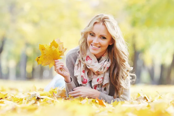 Donna sdraiata in foglie d'autunno — Foto Stock