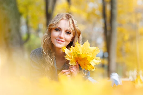 Femme gît dans les feuilles d'érable — Photo