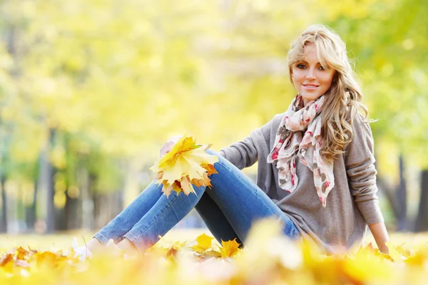 Donna seduta nel parco autunnale — Foto Stock