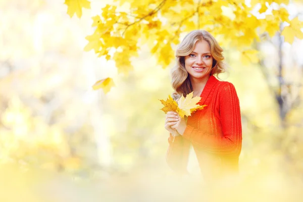 Frau sitzt im Herbstpark — Stockfoto