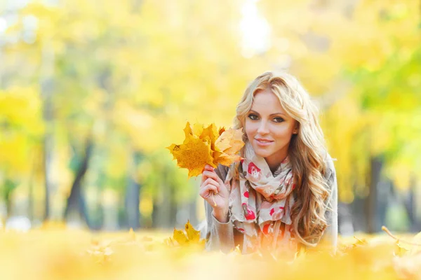 Vrouw liggen in de herfst bladeren — Stockfoto