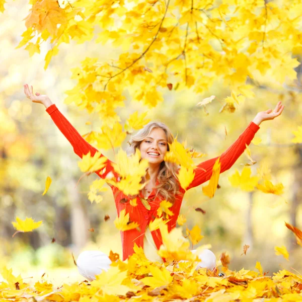 Frau wirft Herbstblätter — Stockfoto