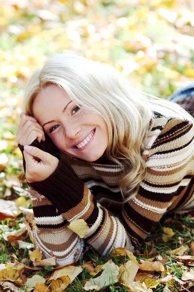 Mujer en hojas de otoño — Foto de Stock