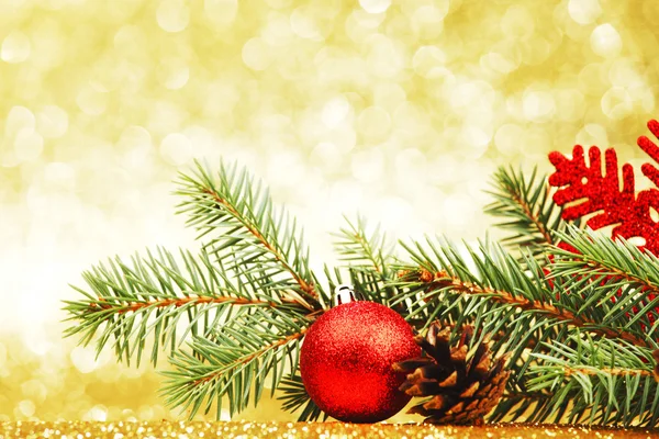 Biglietto natalizio con ramo di abete e decorazione su sfondo dorato glitter — Foto Stock