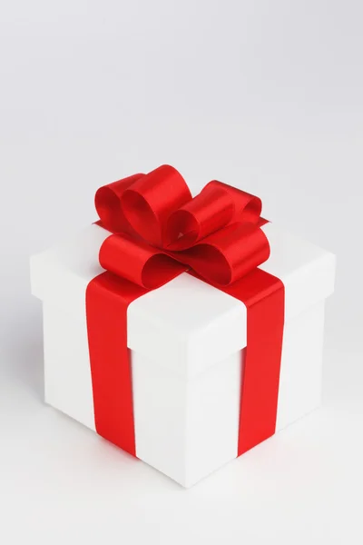 One white gift box with red bow on white background — Stock Photo, Image