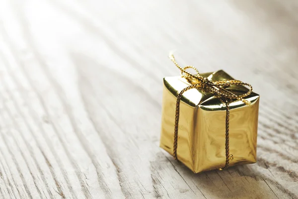 Pequeña caja de regalo sobre fondo de madera macro primer plano —  Fotos de Stock