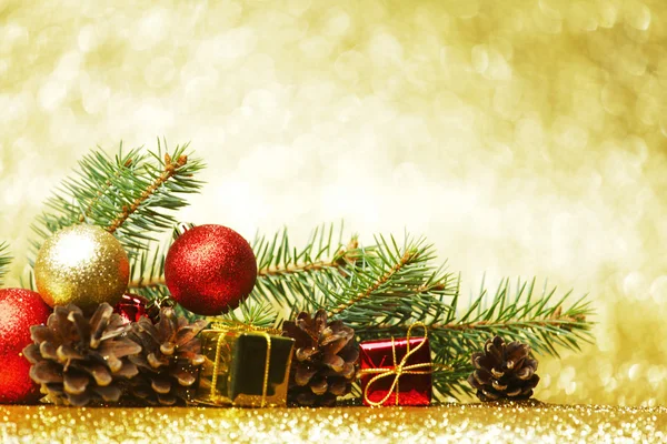 Tarjeta de Navidad con rama de abeto y decoración sobre fondo dorado brillo — Foto de Stock