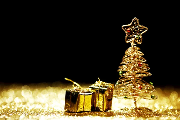 Hermoso árbol de Navidad decorativo dorado y regalos sobre fondo de brillo dorado — Foto de Stock