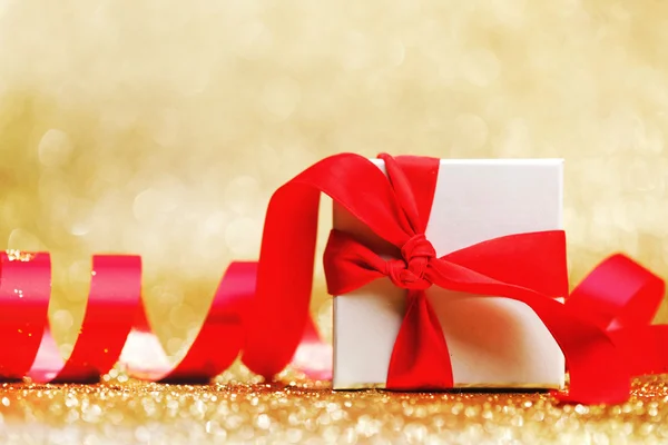 Белая подарочная коробка с красной лентой — стоковое фото