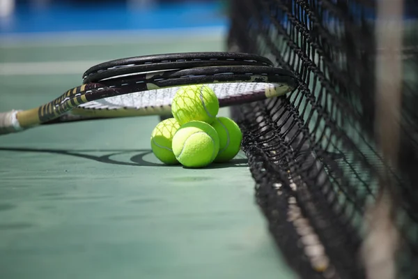 Tennisbälle und Schläger auf dem Platz — Stockfoto