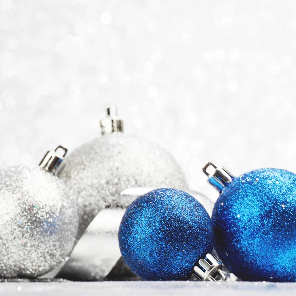 Decoratieve kerstballen op licht zilver bokeh achtergrond — Stockfoto