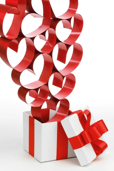 Witte doos met rode linten en decoratieve harten geïsoleerd op witte achtergrond — Stockfoto