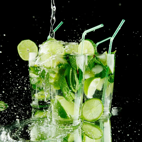 Hälla färska mojito cocktail i glas isolerad på svart bakgrund — Stockfoto