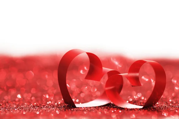 Red ribbon hearts on glitters — Stock Photo, Image