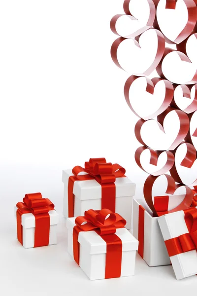 White boxes with red ribbons and decorative hearts isolated on white background — Stock Photo, Image