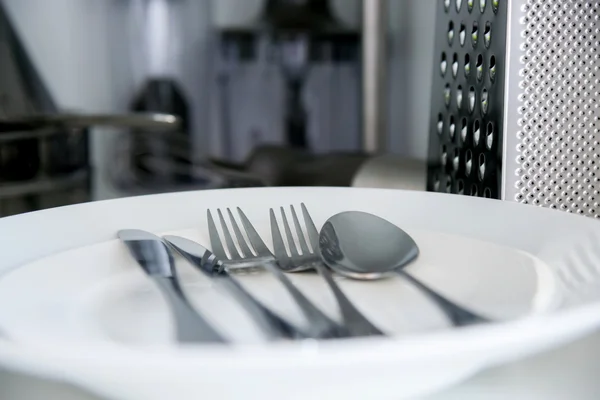 Cuchillo tenedor, cuchara y mesa sobre fondo blanco — Foto de Stock
