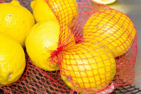 Limones en el embalaje neto en la tienda de comestibles Imágenes de stock libres de derechos