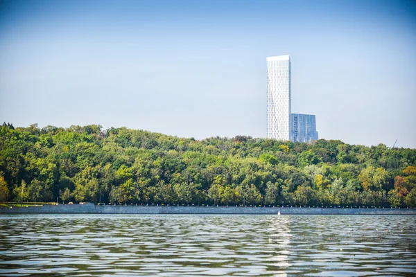 Городской пейзаж: река, парк и небоскреб — стоковое фото