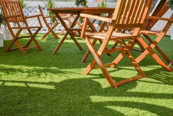 Trästolar och bord på det gröna gräset — Stockfoto